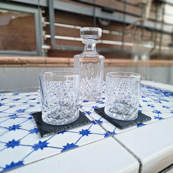 classic_whiskey_decanter_with_two_glasses_and_coasters_on_table