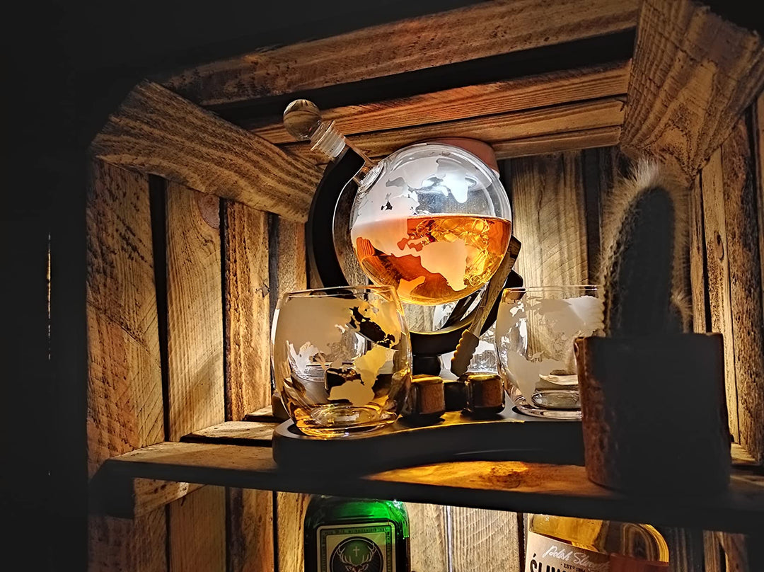 globe decanter 4 glasses on shelf with whiskey bottle and lights