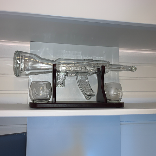 rifle_ak47_whiskey_decanter_on_shelf_with_glasses_and_wooden_standard