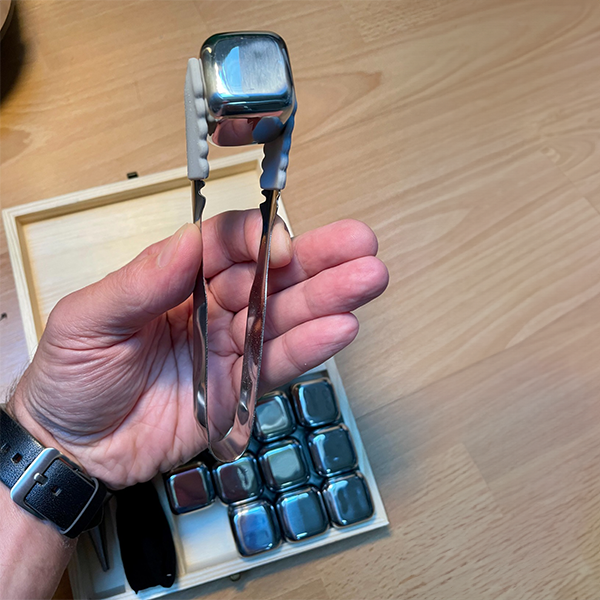 stainless_steel_whiskey_cooling_stone_in_ice_tong_in_hand